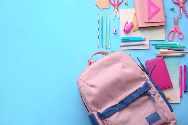 Schulrucksack und Schreibwaren auf farbigem Hintergrund - Foto, Bild