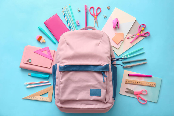 School backpack and stationery on color background - Φωτογραφία, εικόνα