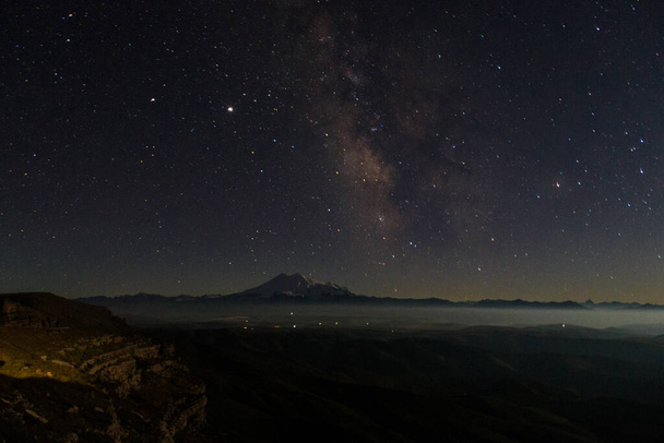 Elbrus and the Milky Way in a clear night sky. View from the Bermamyt Plateau, Karachay-Cherkess Republic, Russia - Φωτογραφία, εικόνα