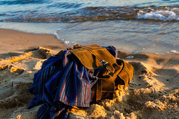Concept de voyage et vacances. Plage de sable vide au coucher du soleil. Sac à dos marron élégant de voyageur sur le bord de la mer. Mer Baltique, Hel, Poméranie, Pologne - Photo, image