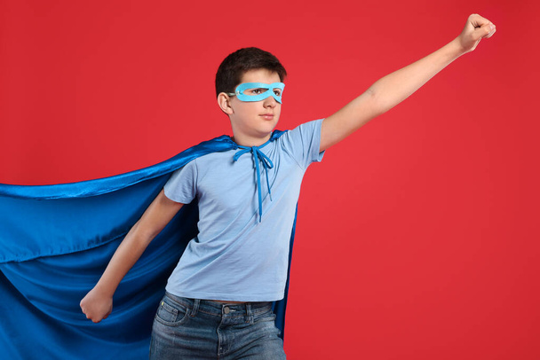 Teenage boy in superhero costume on red background - Zdjęcie, obraz