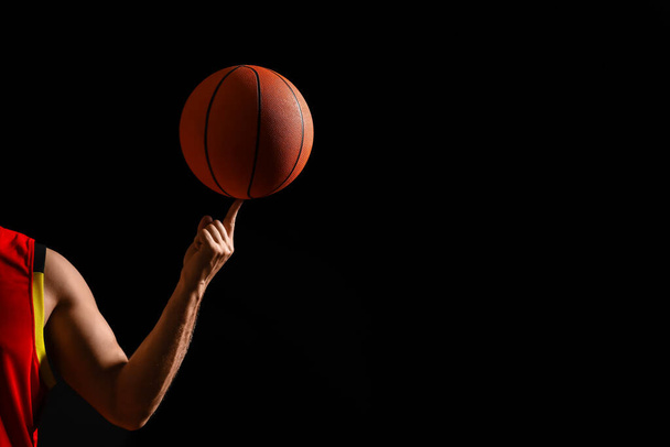 Basketball player spinning ball on black background, closeup. Space for text - Fotoğraf, Görsel