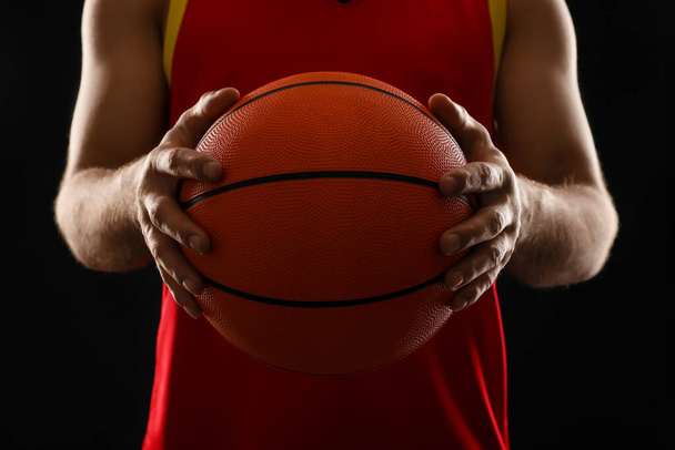 Basketball player with ball on black background, closeup - Фото, изображение