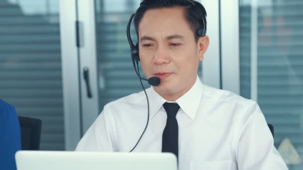 Zakenman die een headset draagt en actief op kantoor werkt - Video