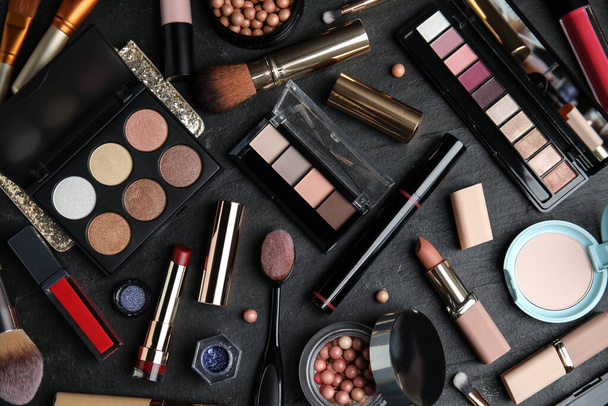 Flat lay composition with makeup products on black slate table - Foto, Imagem
