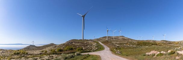 Vista panoramica sulle montagne Pisao, con turbine eoliche e cielo blu sullo sfondo, in Portogallo - Foto, immagini