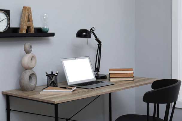 Comfortable workplace with modern laptop near light grey wall indoors - Fotoğraf, Görsel