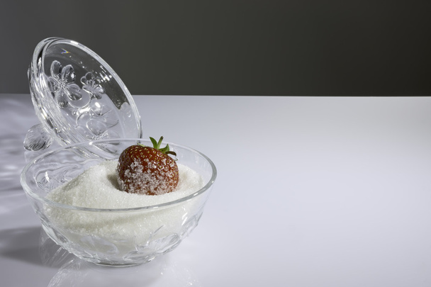 Fresa cubierta de azúcar en un tazón con azúcar
 - Foto, Imagen