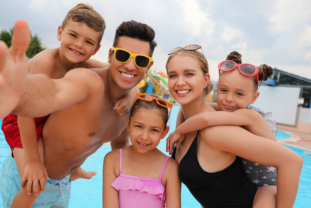 Happy family taking selfie near pool in water park - Photo, Image