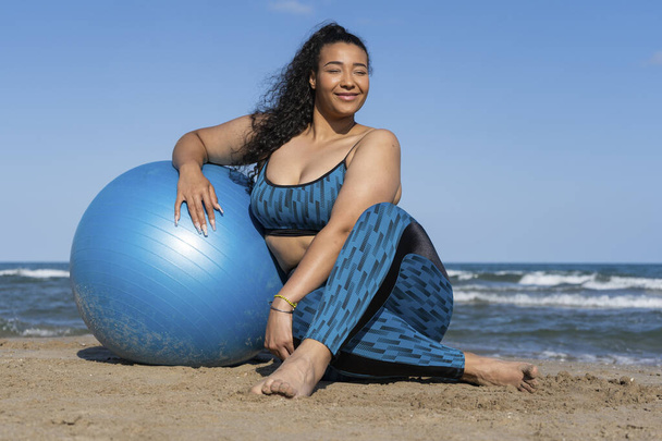 Concepto de entrenamiento de yoga y fitness. Entrenamiento femenino joven en la playa. - Foto, imagen
