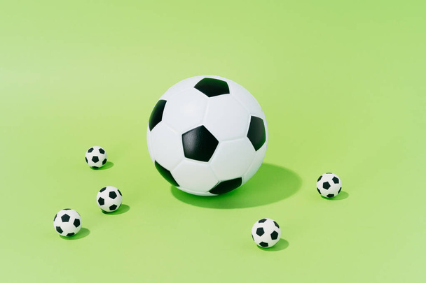 Soccer balls of different sizes on a green background. concept of football and sport. - Foto, immagini