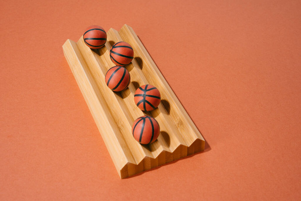 різні баскетбольні м'ячі на дерев'яному та червоному тлі. спорт і змагання. копіювання простору
. - Фото, зображення