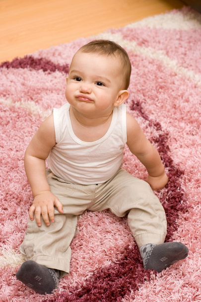 Cute caucasian baby sitting on the carpet - Fotoğraf, Görsel