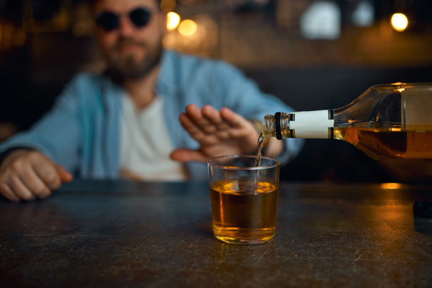 Чоловік в сонцезахисних окулярах відмовляється пити алкоголь
 - Фото, зображення