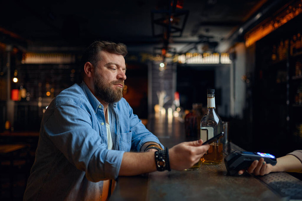 Man pays by phone at the bar counter - Photo, Image