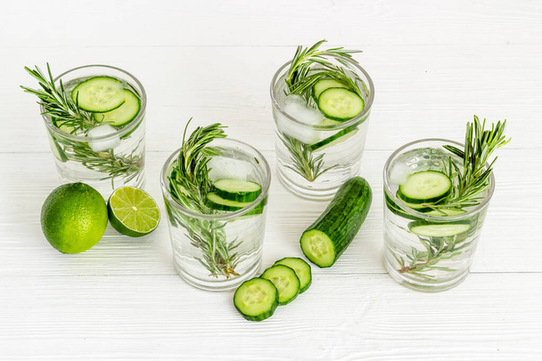 Lemonade with cucumber lime and herbs in glasses - 写真・画像