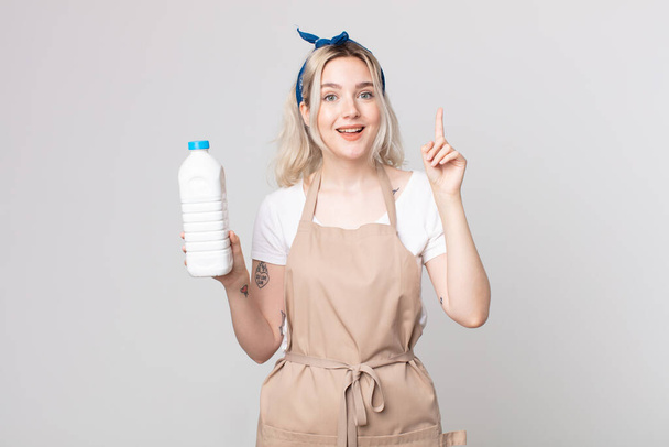 young pretty albino woman feeling like a happy and excited genius after realizing an idea with a bottle of milk - Photo, image