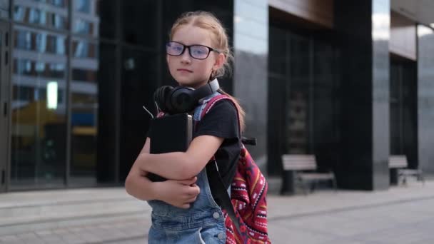  roztomilý kavkazský ryšavý dívka v brýlích s knihami a batohem - Záběry, video