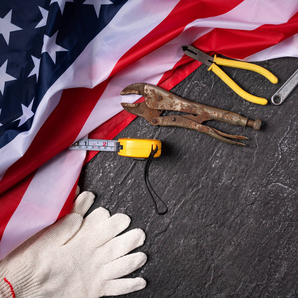 Top view design concept of American Labor Day with working tools on slate table background. - Фото, изображение