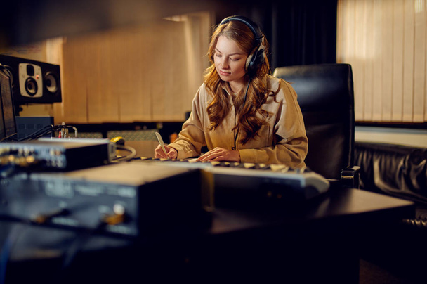 Női mérnök fülhallgatóban, stúdió - Fotó, kép