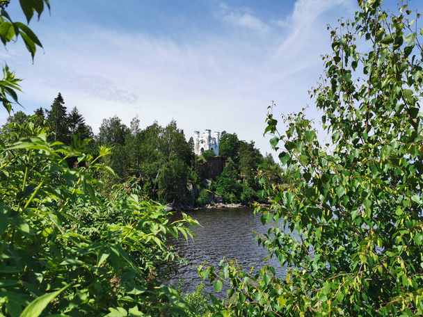 Каплиця Людвігсбурга на острові Людвігштайн в природному парку Монрепос Рок у Виборзі проти прекрасного блакитного неба з хмарами.. - Фото, зображення