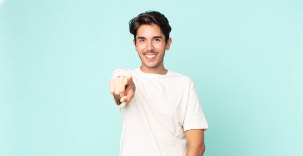 hispanic handsome man pointing at camera with a satisfied, confident, friendly smile, choosing you - Foto, Bild