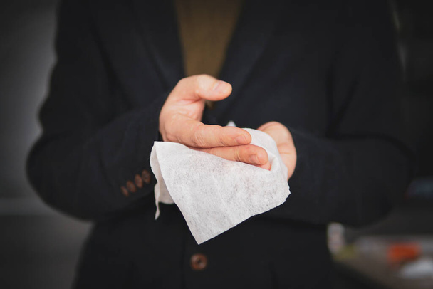 L'homme se nettoie les mains avec une serviette hygiénique antibactérienne après avoir empêché la propagation du virus et des bactéries. homme d'affaires désinfecte ses mains après avoir serré la main - Photo, image