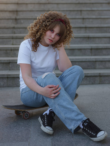Lady summer in the city, posing with a board, longboard skate. Fashion style, free space for text. Young female skateboarded relaxing at city park. - Photo, Image