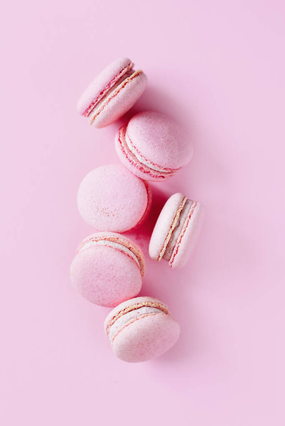 Leckere französische Macarons auf rosa Pastell-Hintergrund. Platz für Text. - Foto, Bild