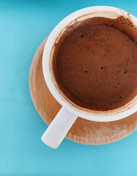 Темный традиционный кофе в белой чашке на ярко-синем фоне - Фото, изображение