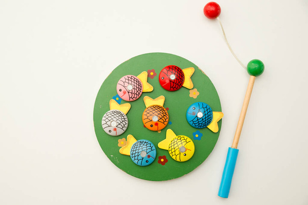 Let's go fishing. Wooden fishes and fishing rod with magnet on the tip. Early education, focus exercises. Coordination and fine motor activities for preschoolers. - Photo, image