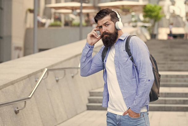 Engineered for modern life. Bearded man wear headphones outdoors. Listening to music in modern age. Hi-Fi audio. Digital sound. Modern technology. Modern lifestyle - Photo, image