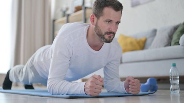 Close up of Strong Mature Adult Man doing Plank on Yoga Mat at Home - Fotó, kép