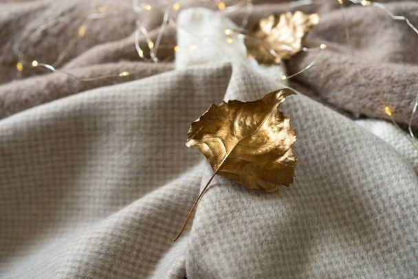 Куча трикотажной одежды с осенними золотыми листьями, теплый фон, трикотаж, пространство для текста, осенняя зимняя концепция. - Фото, изображение