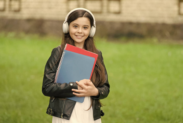 Girl listening audio carry textbooks on way to school, language lessons concept - Zdjęcie, obraz