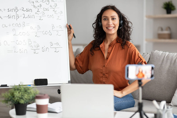 Female teacher in headphones explaining trigonometric functions to students online - Photo, Image