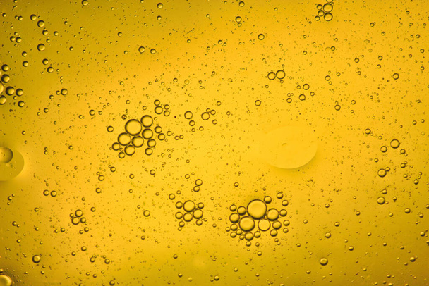 泡の動きの明るい黄色の液体の背景のクローズアップビュー - 写真・画像