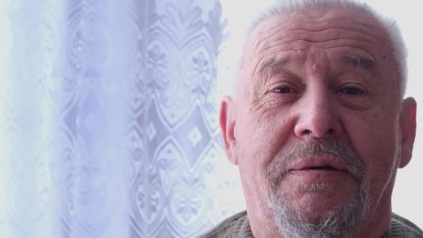 Close-up portret van een volwassen man met grijs haar.  - Video