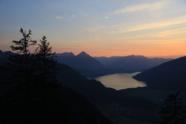 Sunset scene in the Swiss Alps. Outlines of Mount Niesen, Stockhorn and others. Lake Thun. - Φωτογραφία, εικόνα