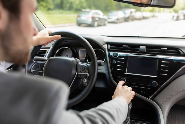 Mann benutzt GPS-Navigationssystem im Auto für Fahrt auf neuer Straße in der Stadt - Foto, Bild