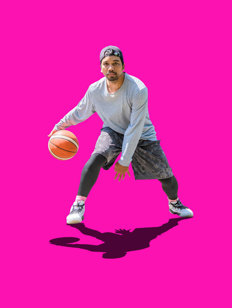 Повна фотографія азіатського чоловіка, який грає в баскетбол, одягаючись у вільний одяг на кольоровому тлі з обрізаною стежкою. - Фото, зображення