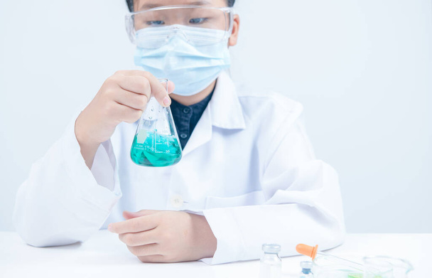 Nuoret tutkijat ravistelevat sinistä nestemäistä kemikaalia valkoisella pohjalla eristetyssä erlenmeyerpullossa. Tiede laboratorio ja koulutus käsite. - Valokuva, kuva