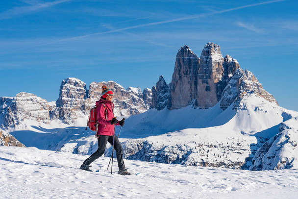 szép aktív középkorú nő hótalpas alatt a híres Three Peaks Prato Piazzo fel a Monte Specie a három tölgyfa Dolomite területén falu Innichen három csúcs a háttérben, Dél-Tirol, Olaszország - Fotó, kép