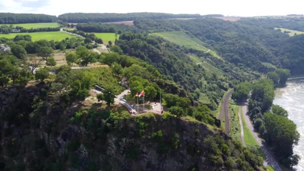 Video from a drone moving away from a cliff on the Rhine in Germany, visible road on both sides of the river. - Πλάνα, βίντεο