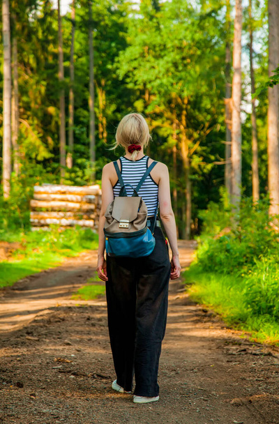 Blondynka w spodniach budząca się w lesie - Zdjęcie, obraz