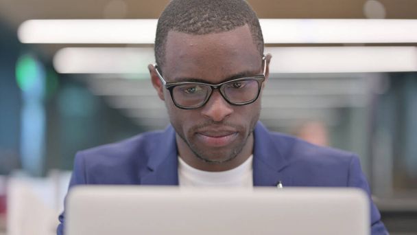 Giovane imprenditore africano che lavora sul computer portatile in ufficio - Foto, immagini