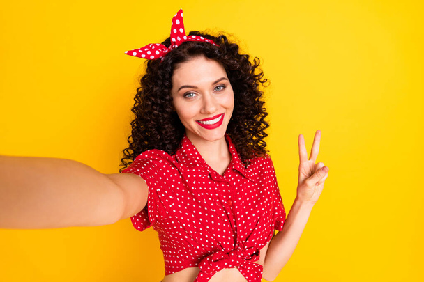 Zdjęcie cute optymistyczne brunetka włosy lady do selfie show v-sign nosić czerwony top band izolowane na żółtym tle - Zdjęcie, obraz