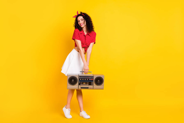Full size photo of cute optimistic brunette hair lady hold boom box wear red top skirt sneakers isolated on yellow background - Fotografie, Obrázek