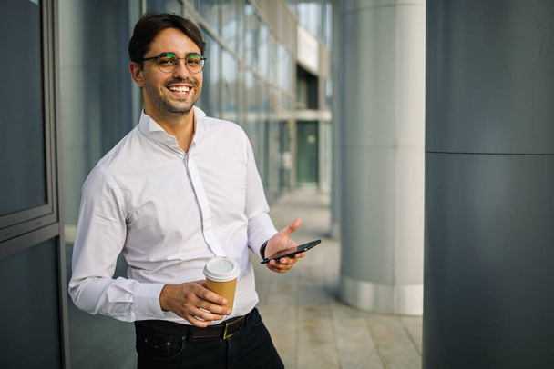Porträt eines selbstbewussten Geschäftsmannes vor dem Hintergrund eines Bürogebäudes - Foto, Bild