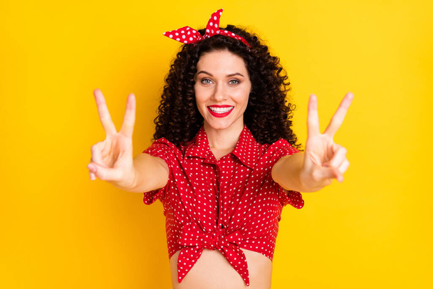 Photo of cute optimistic brunette hair lady show v-sign wear red top isolated on yellow color background - Photo, Image